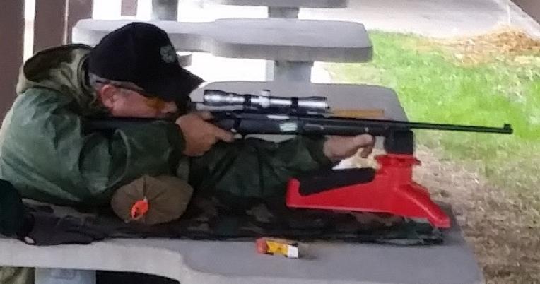 A man sights in a rifle at an MDC shooting range.